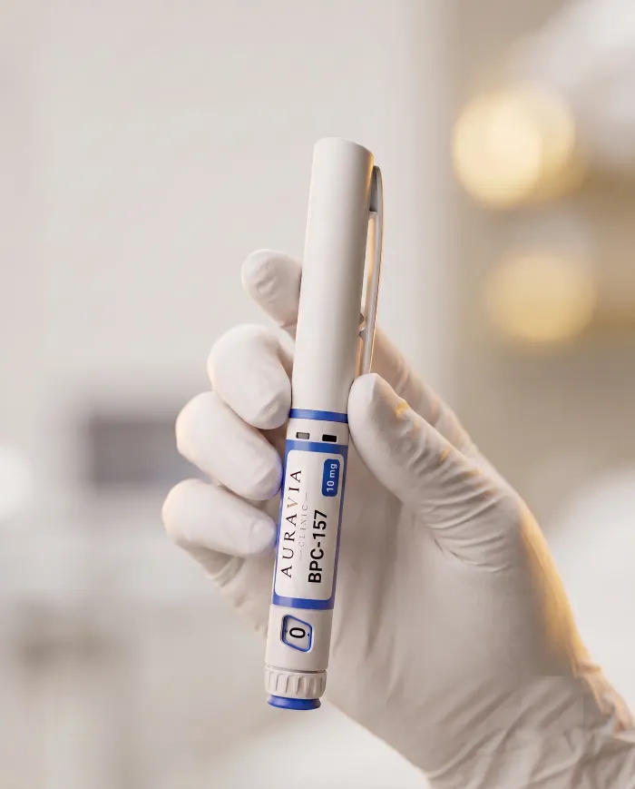 Fabrycznie napełniony pen z BPC-157 (10 mg) w dłoni w rękawiczce, z nasadką i pokrętłem ze skalą